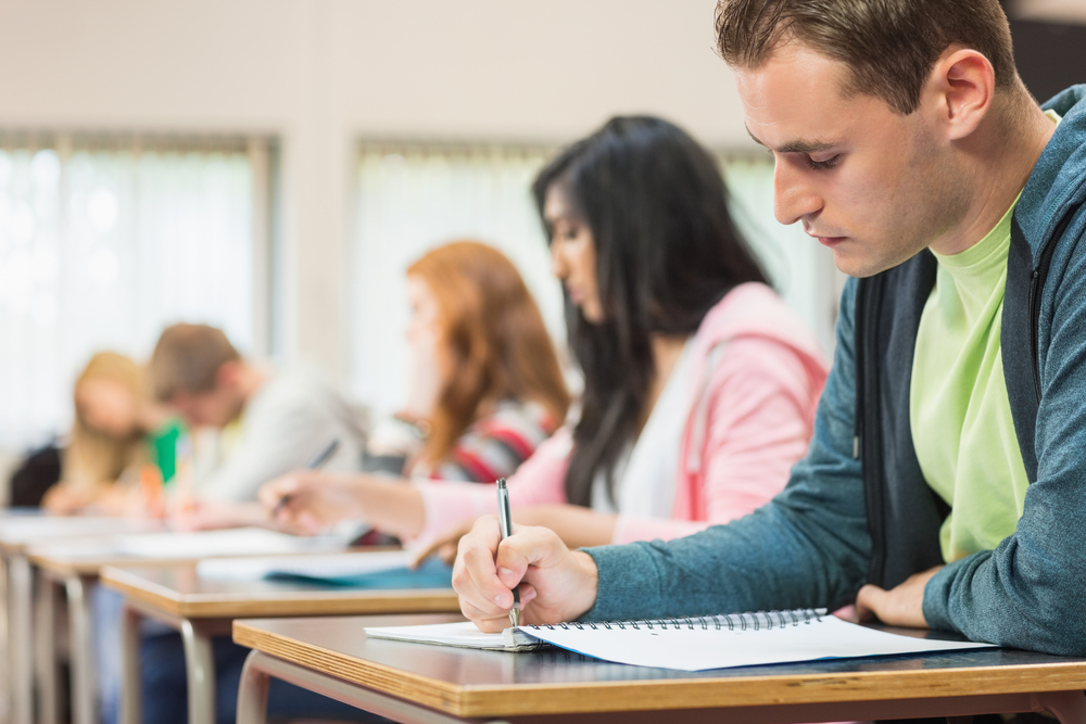 Side view of a group of young students writing notes in the classroom-1